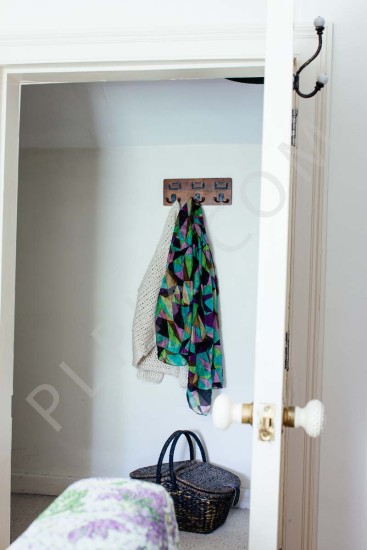 Interior photography of a coat rack with a wicker basket