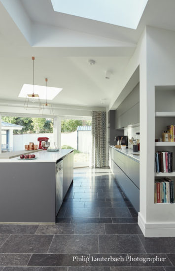 Openplan kitchen with stone fllooring storage pendant lighting island countertop sliding glass patio door skylights