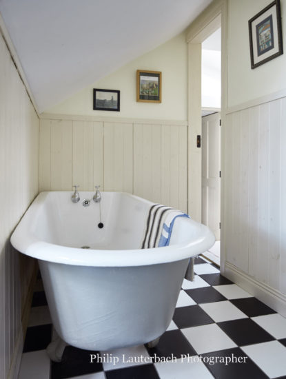 Bathroom floor tiling timber panels door way artwork bath tub