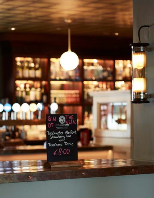 Bar seating tables timber panels pendant lighting signage